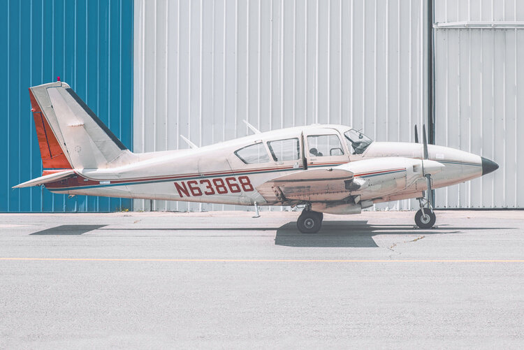 Single engine white plane in front of a white and blue wall