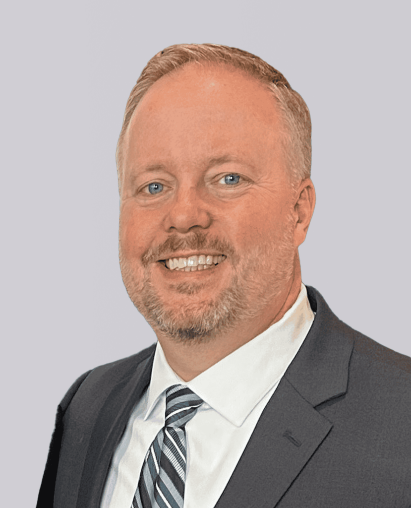 Professional headshot of a man smiling in a blue suit